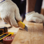 Male,Contractor,Working,With,Wooden,Plank,And,Cutter,On,The