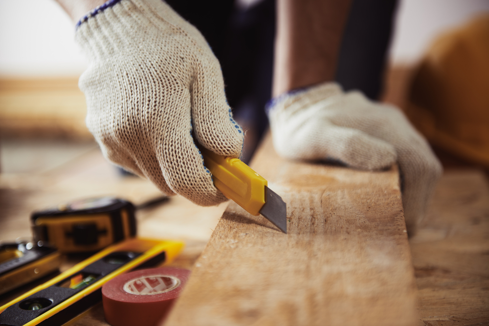 Male,Contractor,Working,With,Wooden,Plank,And,Cutter,On,The